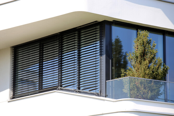 Große Fenster mit Außenrolläden und Jalousien als Sonnenschutz